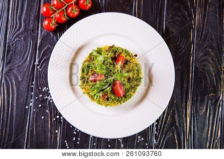 Salad From Bulgur And Fresh Vegetabes On White Plate In Restaurant