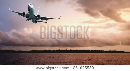 Australian Colourful Sunset Seascape With An Airborne Passenger Jet Airliner Flying High In An Orang