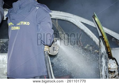 Firefighter Douses A Fire During, Fire Suppression On Car
