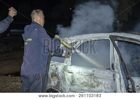 Firefighter Douses A Fire During, Fire Suppression On Car