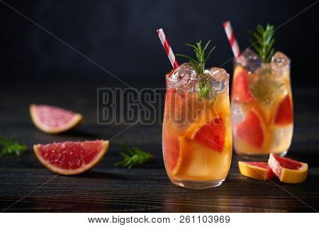 Refreshing Cocktail With Ice Grapefruit And Rosemary  On A Black