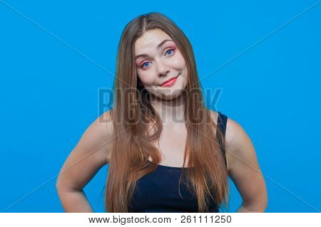 Young Pretty Woman With Astonished Smile, Blue Eyes. Funny Face. Blue Background, Studio, Isolated, 