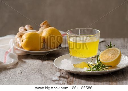Ginger Tea With Lemon, Ginger Root And Rosemarry On Wooden Background. Small Glass Transparent Pitch