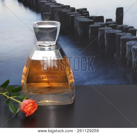 Vera Wang, Fragrance For Ladies, Large Perfume Bottle In Front Of The Picture Of A Groyne In The Sea