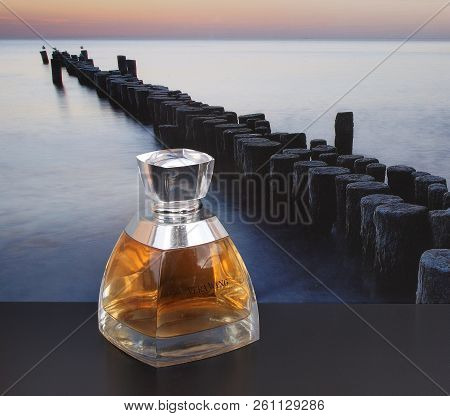Vera Wang, Fragrance For Ladies, Large Perfume Bottle In Front Of The Picture Of A Groyne In The Sea