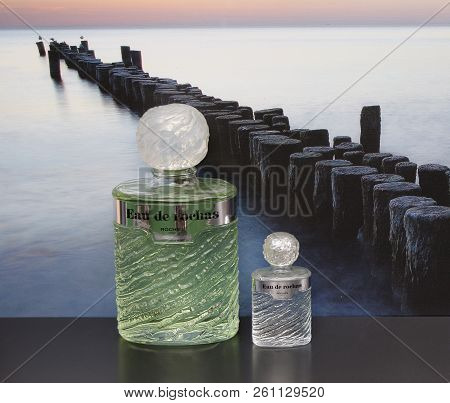 Eau De Rochas, Fragrance For Ladies, Large Perfume Bottle Next To A Commercial Perfume Bottle In Fro