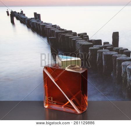 Kl Homme, Mens Fragrance, Large Perfume Bottle In Front Of The Picture Of A Groyne In The Sea
Kassel