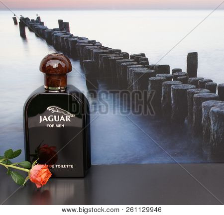 Jaguarfor Men, Eau De Toilette, Large Perfume Bottle In Front Of The Picture Of A Groyne In The Sea 