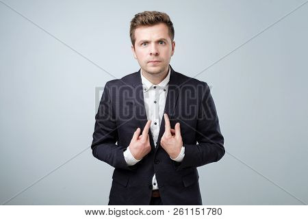 Young European Man In Suit Pointing At Himself, Making Excuses Or Verbally Defending, Having Perplex