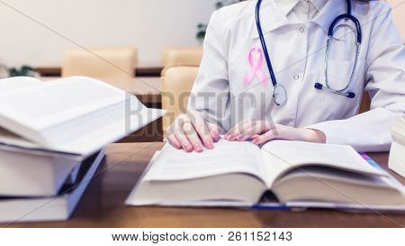 Female Doctor With Pink Ribbon, Medical Student For Textbooks. Protocols For Diagnosis And Treatment