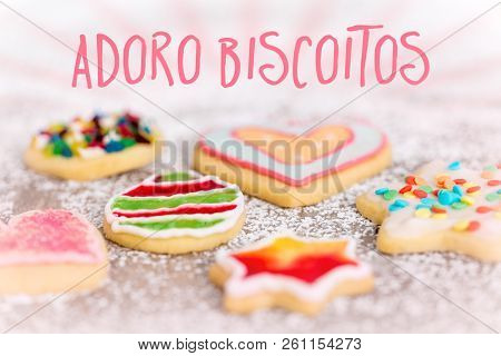 Sweet And Colorful Cookies On Icing Sugar Background, Spanish Text Adoro Biscoitos Which Means I Lov