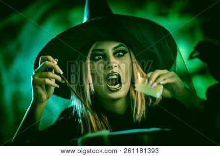 Witch With Awfully Face And Magic Candle In Her Hand In Foggy Surroundingscooks Poison Soup In Boili