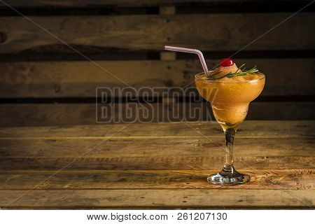 Orange Mulata Cocktail In A Glass With Lime And Tubules On A Wooden Background With Studio Light