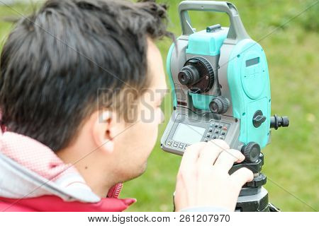 Civil Engineer Land Survey With Tacheometer Or Theodolite Equipment. Worker Checking Construction Si