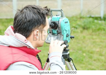 Civil Engineer Land Survey With Tacheometer Or Theodolite Equipment. Worker Checking Construction Si