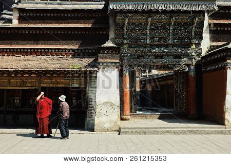 Labrang Monastery, Xiahe, Gansu Province / China - Jun 6 2011: A Tibetan Monk Is Talking With A Pilg
