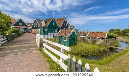 Typical Dutch Village Scene With Wooden Houses And Bridge Over Canal On The Island Of Marken In The 