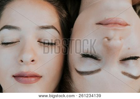 Two girlfriends lying next to each other
