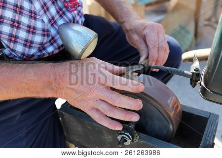 Old Grinder With Manual Grindstone Grinding The Blade Of Billhook