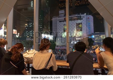 Shibuya, Tokyo, Japan - April 30, 2018: People Sitting In Coffee Shop, Watching Shibuya Crosswalk In