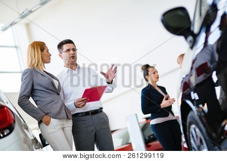 Handsome Salesman At Car Dealership Selling Vehichles