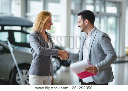 Handsome Salesman At Car Dealership Selling Vehichles