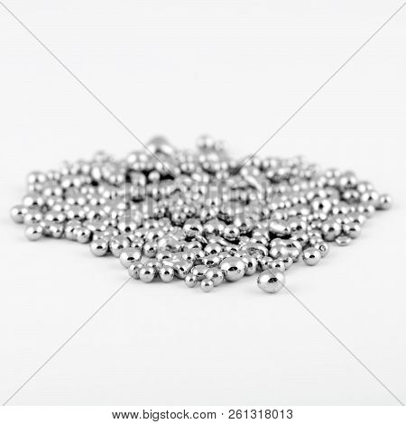 Metallic shiny shapeless mercury like balls are in a pile