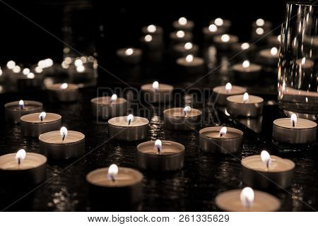 Burring Candles On Decorative Glass. Dark Background. Abstract Photo