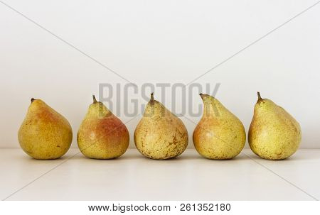 Five Ripe Yellow Pears On A Table On A White Background