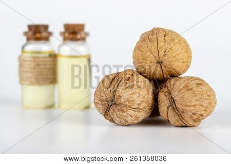 Oil In A Bottle And Walnuts On A White Kitchen Table. Spices And Ingredients Useful In Kuchi.