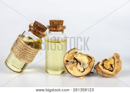 Oil In A Bottle And Walnuts On A White Kitchen Table. Spices And Ingredients Useful In Kuchi.