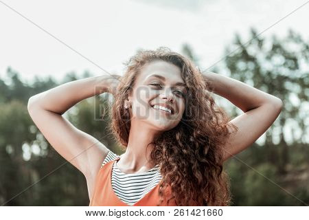 Appealing Good-looking Beaming Curly Dark-haired Woman Smiling Broadly