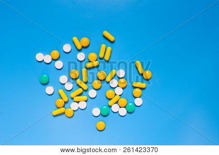 Color Capsules. Medicine Pills On Blue Background Top View Copy Space Pattern