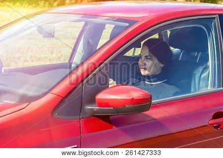 Young, Beautiful, Happy Woman Driving A Red Car. Woman Driving. Business Lady Drives A Car. The Conc