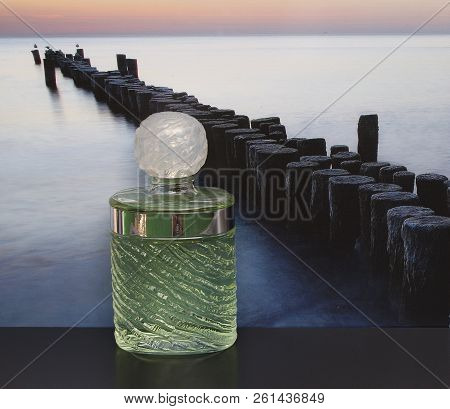 Fragrance For Ladies, Large Perfume Bottle In Front Of The Picture Of A Groyne In The Sea