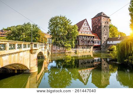 Beautiful Landscape View On The Riverside With Old Tower, House In Nurnberg During The Sunrise, Germ