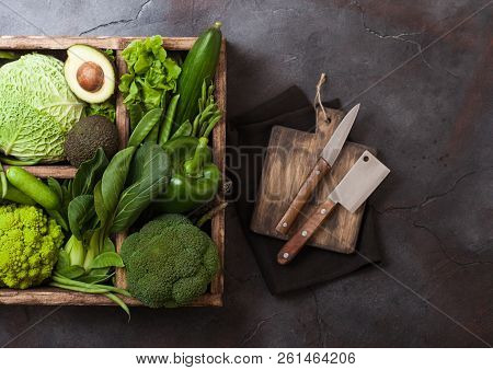 Assorted Green Toned Raw Organic Vegetables In Wooden Box On Dark Stone Background. Avocado, Cabbage