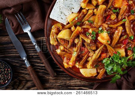 Okra Tomato Stew With Potato Served With Feta Cheese Slices On A Earthenware Plate On A Rustic Table