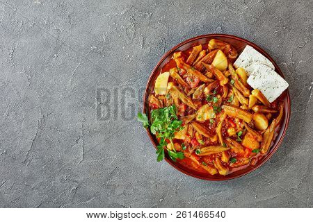 Okra Mpamies Giaxni Stewed With Tomatoes And Potatoes , Served With Feta Cheese Slices On A Clay Pla