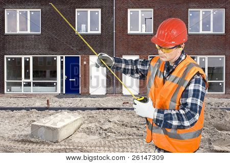 Un trabajador de la construcción comprobar la medición en su regla de primavera