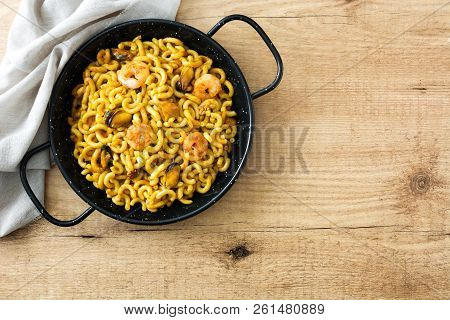 Traditional Spanish Fideua. Noodle Paella On Wooden Table. Top View. Copyspace