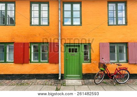 Female Bicycle Waiting For Rider Near Yellow Walls Of Historical Building In Traditional Style Of Co