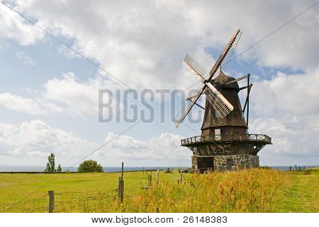 En gammal väderkvarn visas i ett landsbygdsområde. Det finns inga människor kan ses. Horisontellt inramade skott.