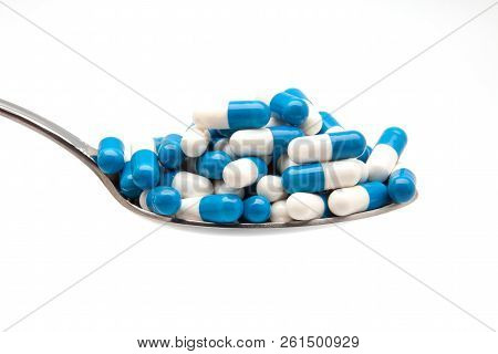 Spoon And Capsulas Medicas On White Background