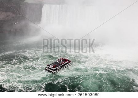 NIAGARA FALLS, ONTARI, CANADA - MAY 29, 2016: Hornblower Niagara Thunder boat with tourists in Niagara Falls view from Canadian sideseen in Niagara Falls.