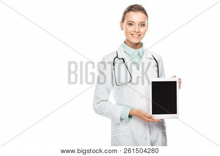 Smiling Female Doctor In Medical Coat Showing Digital Tablet With Blank Screen Isolated On White