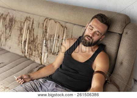 Passed Out Drug Addict Sitting On The Couch After Shooting Up With Heroin; Junkie Overdosed With Int