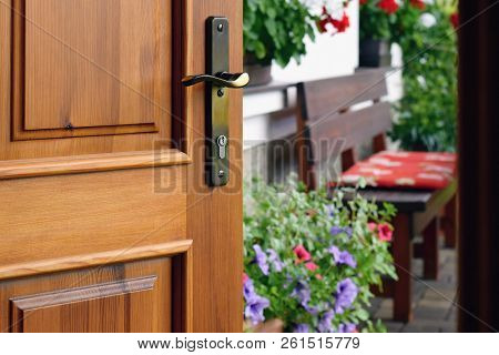 Half Opened Door Into The Beautiful Summer Terrace And  Blooming Garden