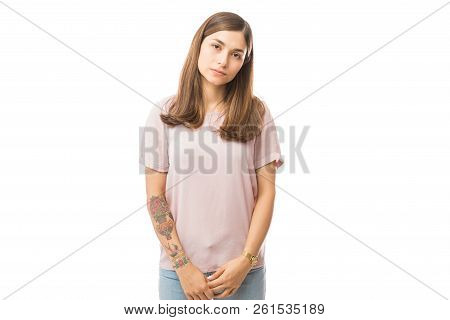 Portrait Of Bored Young Female In Casuals Standing Against White Background
