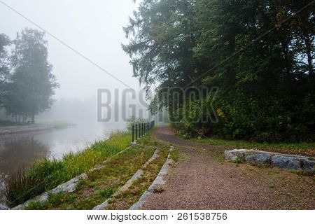 Forssa Finland, Foggy Morning By The River With A Path Beside The Treeline
